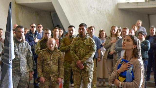 La esposa de un soldado ucraniano asiste a su funeral junto a los compañeros del fallecido este sábado en Kiev