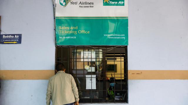 Un hombre observa el mostrador de Tara Air, la aerolínea del avión desaparecido en Nepal, este domingo 29 de mayo en Kathmandu