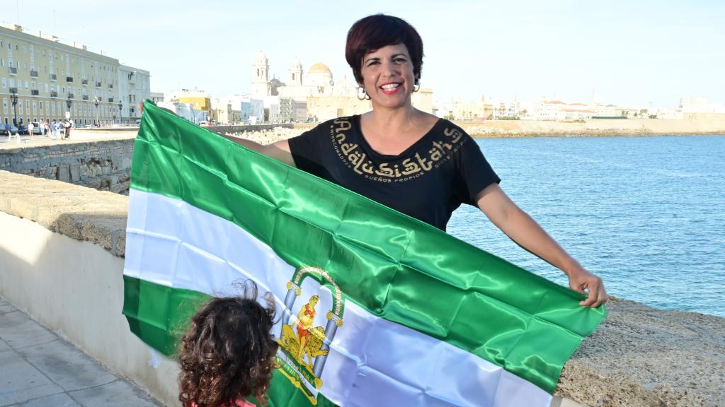 Teresa Rodríguez, junto al mar, con la bandera andaluza y una de sus hijas.