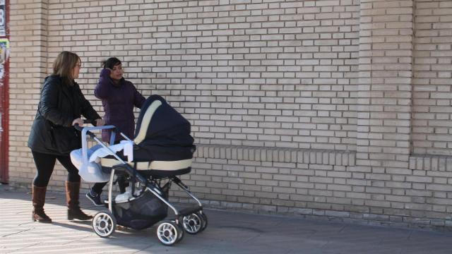 Imagen de archivo de dos madres paseando a sus bebés