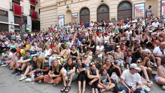 Gente siguiendo la procesión del Corpus en las escaleras del Teatro de Rojas.