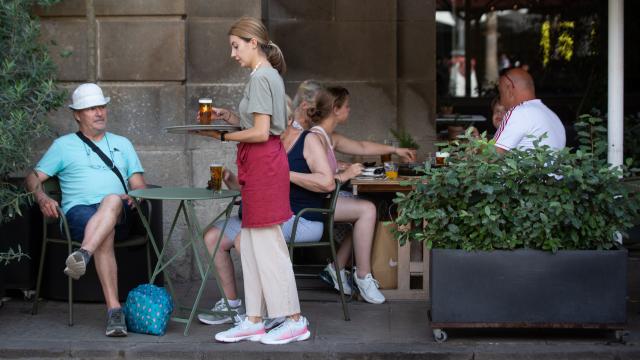 Una mujer trabaja atendiendo una terraza