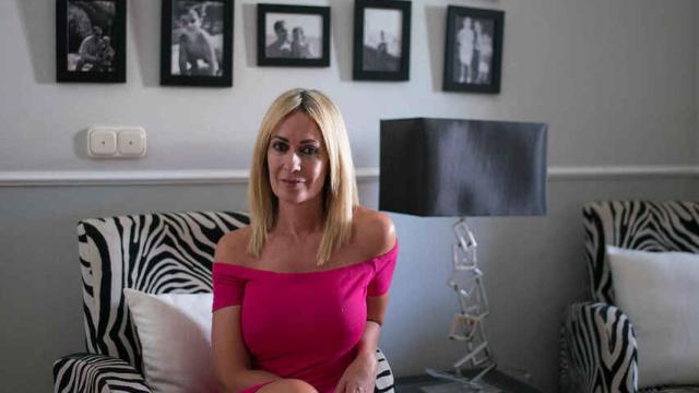 Olvido Hormigos en su casa con fotografías de su familia detrás.