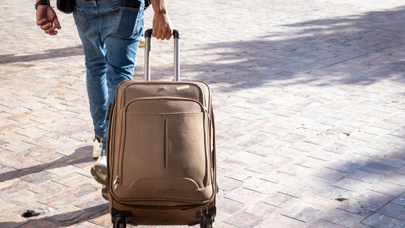 Un turista llevando una maleta.