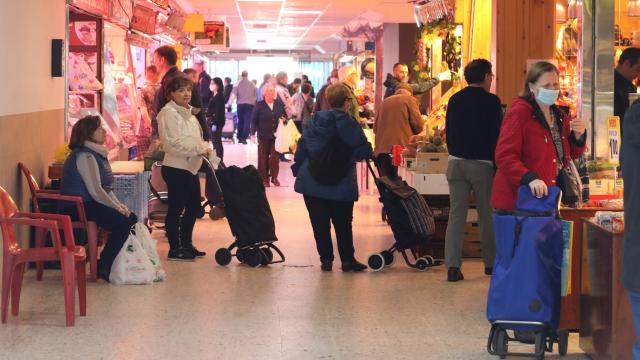 Un grupo de personas comprando en un mercado en Madrid.