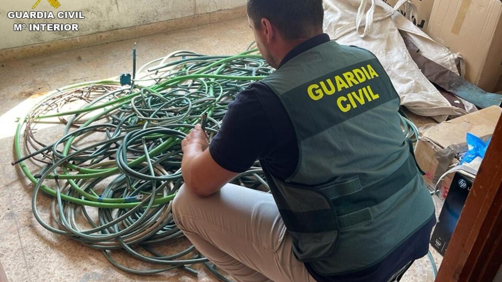 Uno de los agentes con parte del material intervenido.