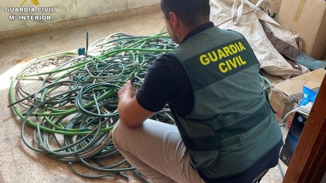 Uno de los agentes con parte del material intervenido.