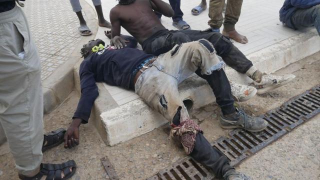 Dos de los migrantes, tras haber saltado la valla de Melilla.