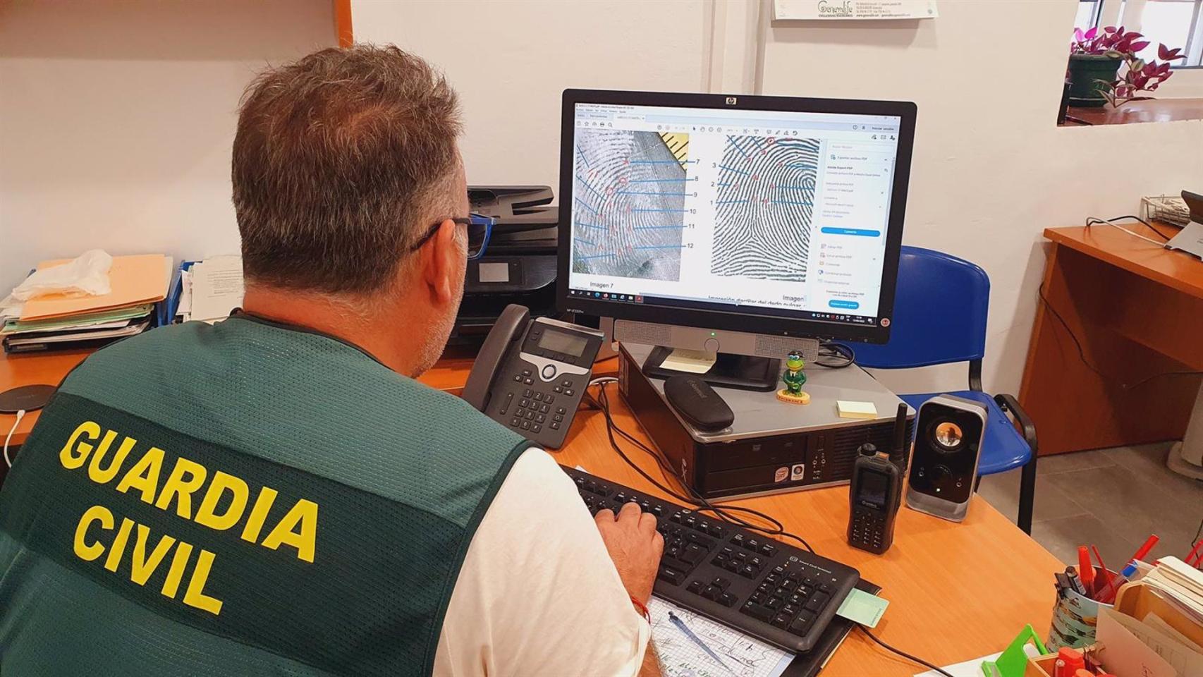 Fotografía de un guardia civil identificando huellas.