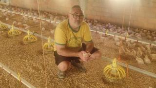 Eloy Ureña, con uno de los pollo que cría y guarda, en su granja.
