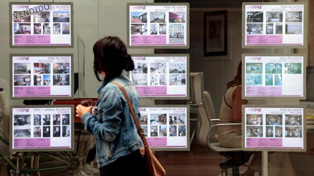 Una mujer pasa por una inmobiliaria.