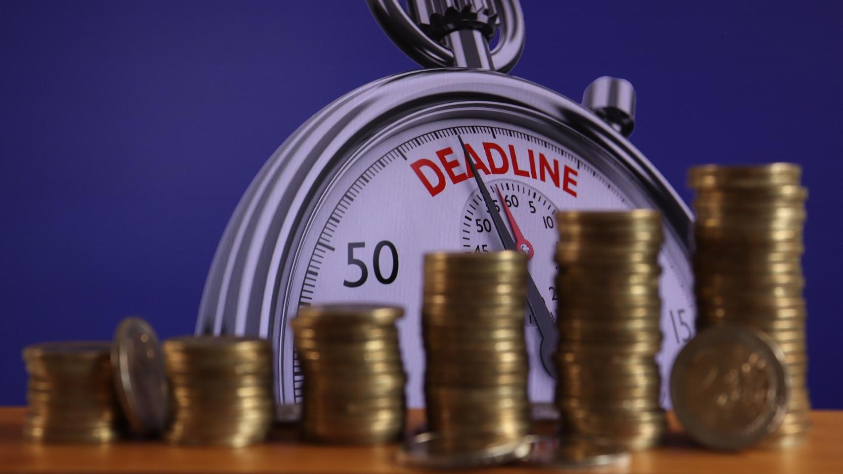 Montones de monedas con un cronómetro que marca la cuenta atrás.