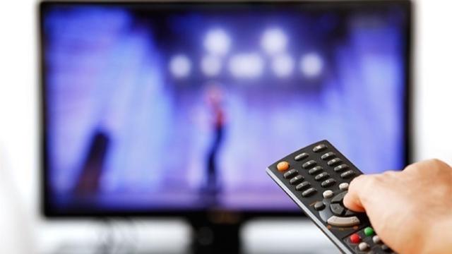 Imagen de un mando apuntado a una pantalla de televisión.