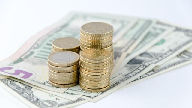 Monedas de euro y billetes de dólar.