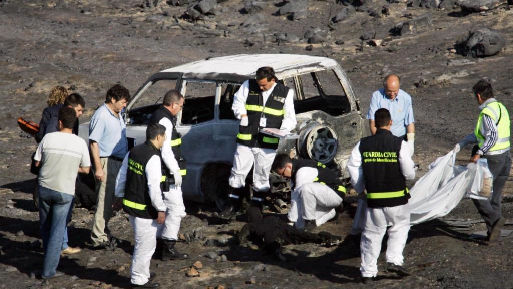 La comitiva judicial y efectivos de la Guardia Civil junto a los cadáveres del retén.