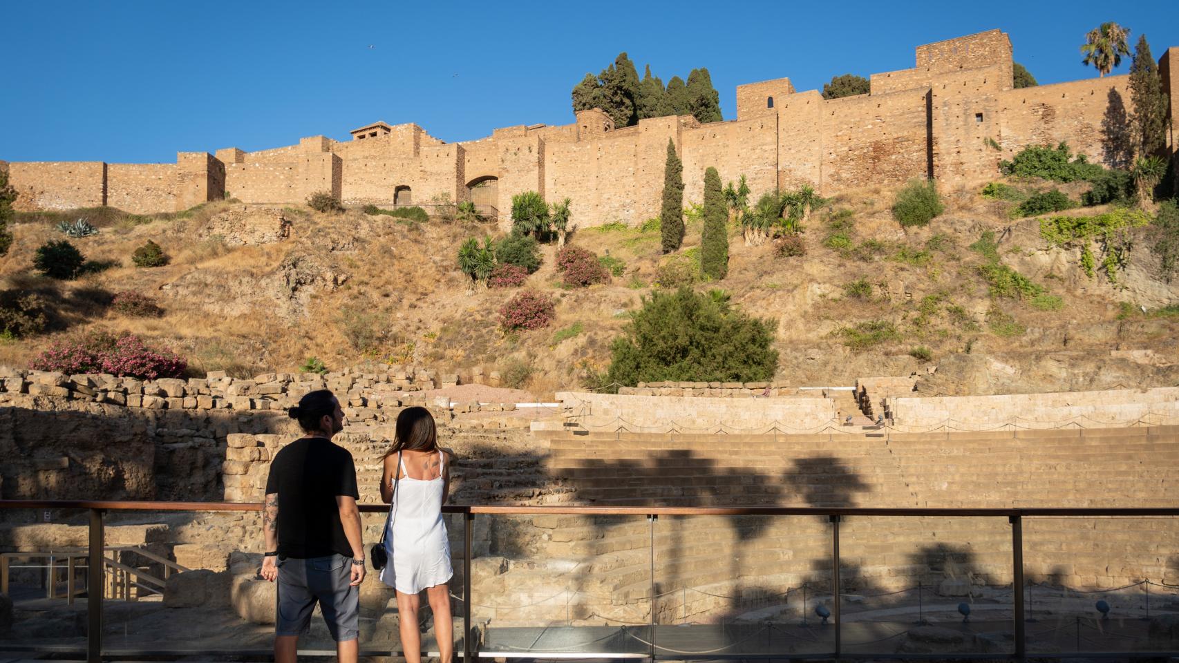 Una pareja pasea junto a la Alcazaba.