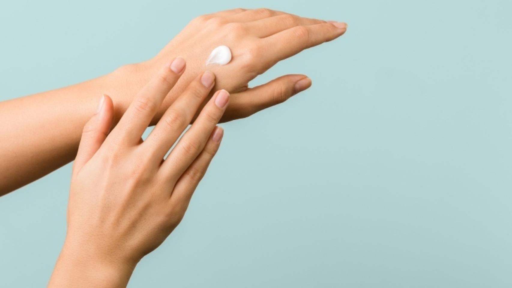 Una persona echándose crema del sol.