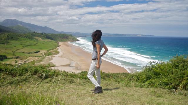 Una mujer contempla la Playa de la Vega en Asturias.