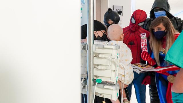 Los superhéroes intentando animar a una bebé.