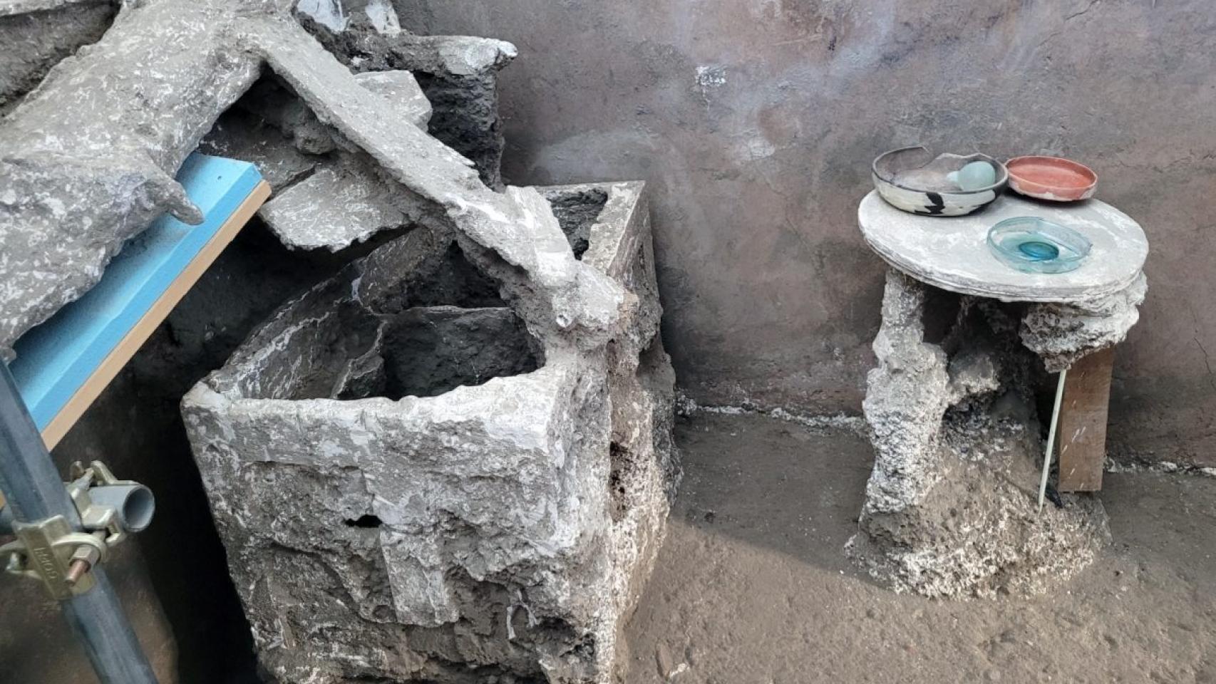 Una de las estancias de la Casa del Larario, con el arcón y la mesa de madera. Foto: Parque Arqueológico de Pompeya.