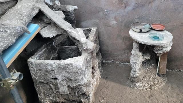Una de las estancias de la Casa del Larario, con el arcón y la mesa de madera. Foto: Parque Arqueológico de Pompeya.