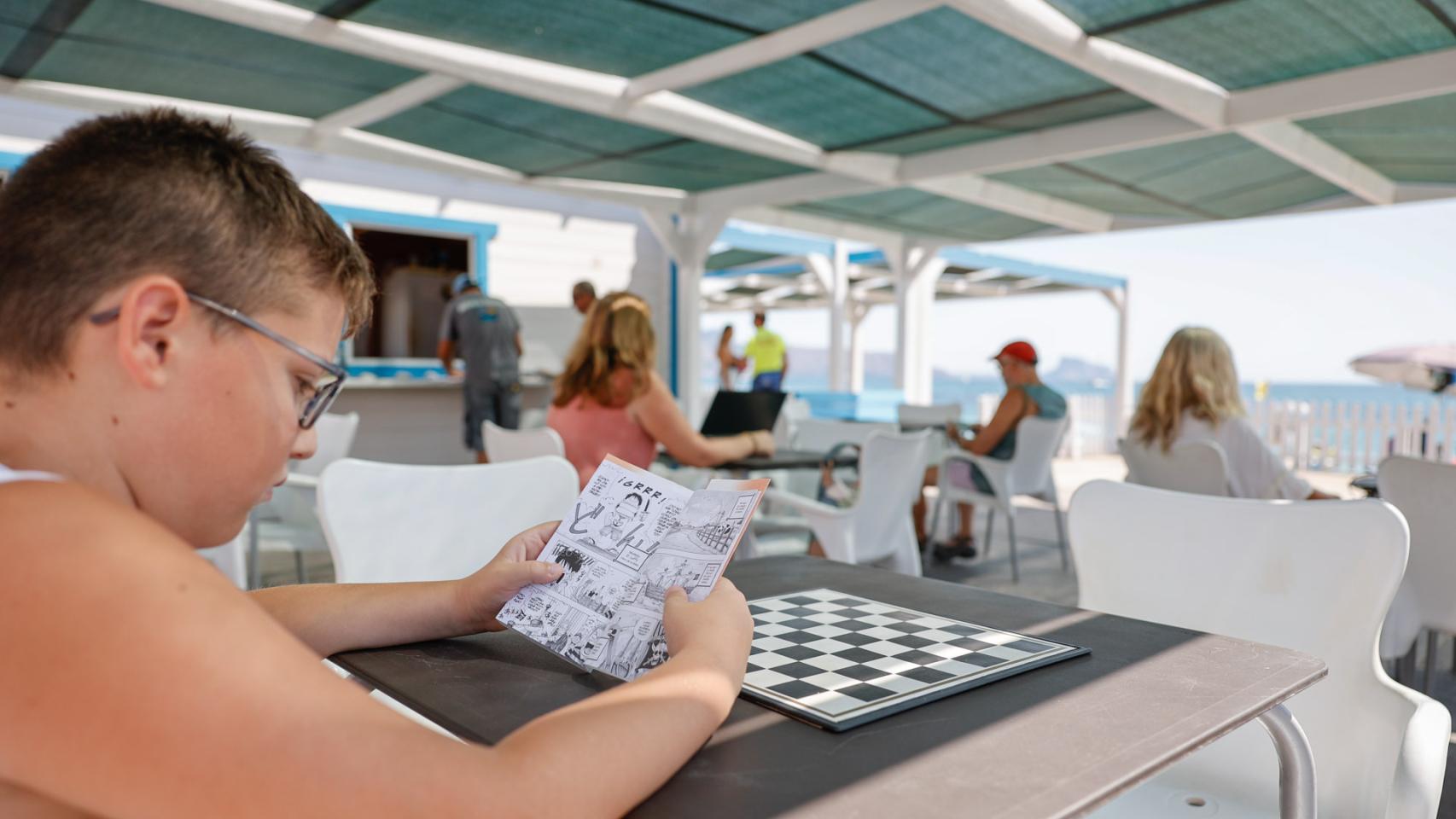 Varios niños en la bilioteca de la Playa de l'Albir de l'Alfàs del Pi.