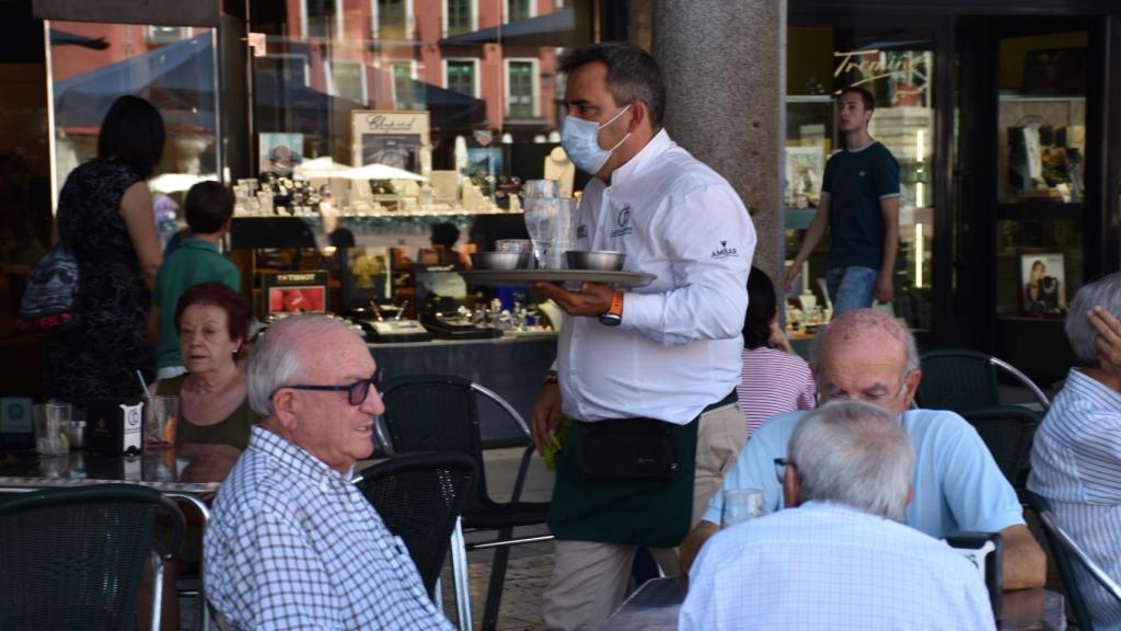 Un camarero sirve en una terraza.