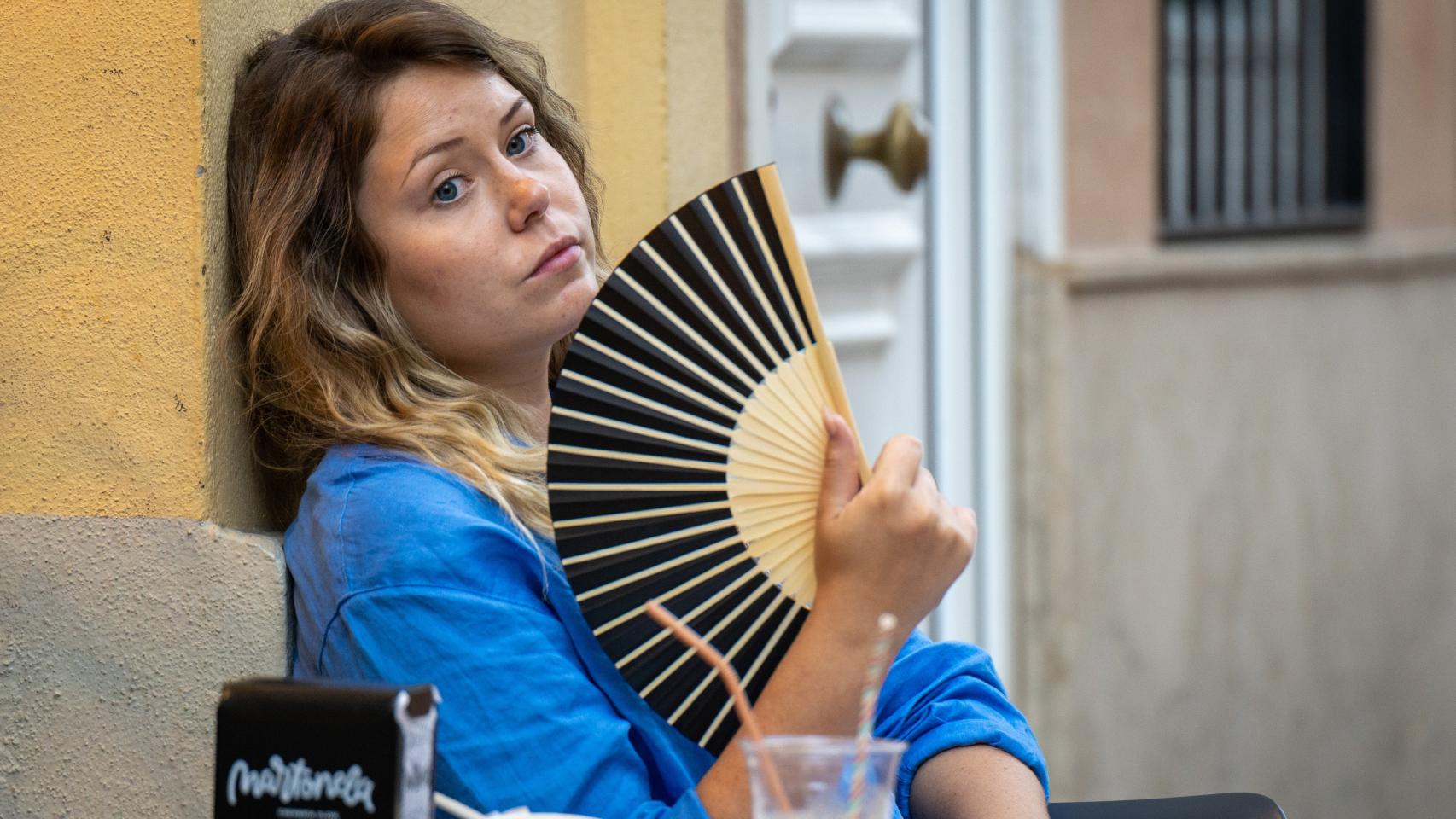 Una mujer abanicándose.
