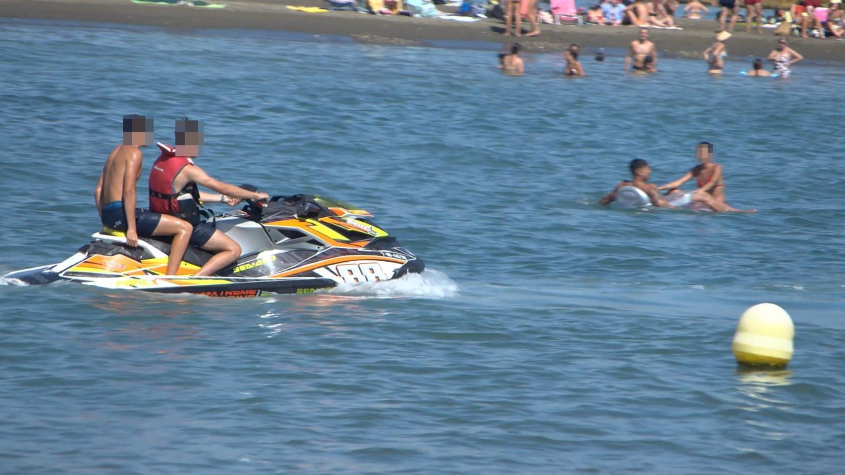 Pasajero en moto acuática sin chaleco salvavidas en una playa de Málaga.