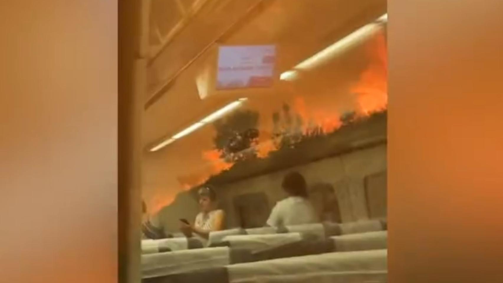Pasajeros en el interior del tren rodeado de llamas.