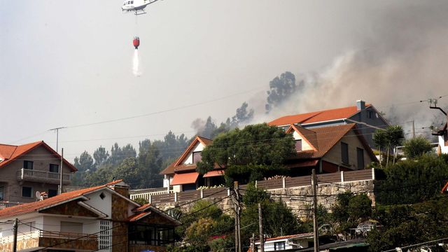 Un helicóptero participa en las labores de extinción del incendio declarado en Meira, Moaña (Pontevedra).