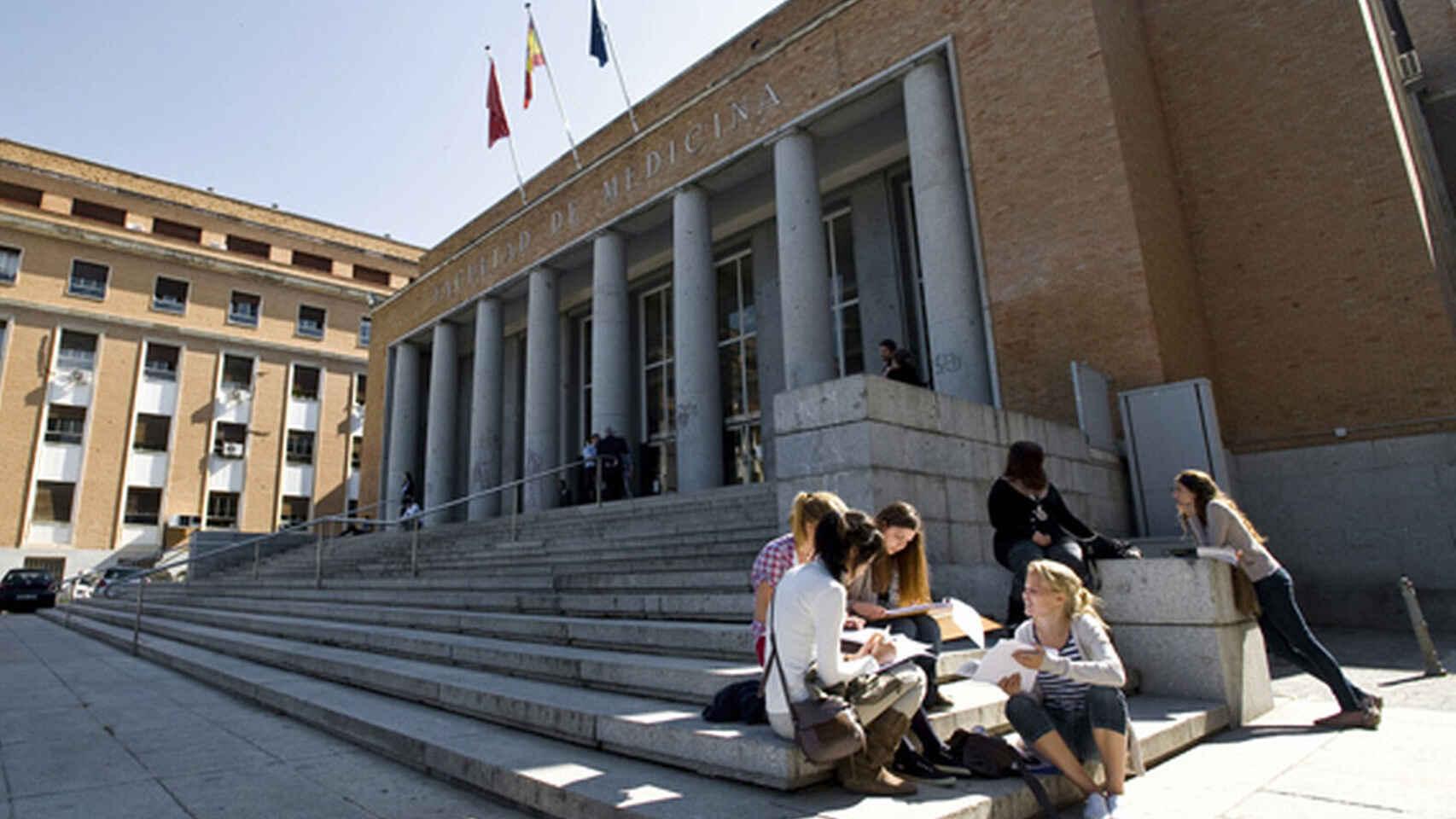 Varios estudiantes a la entrada de una facultad.