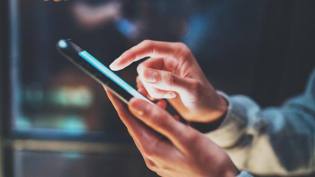 Una mujer interactúa con su teléfono móvil