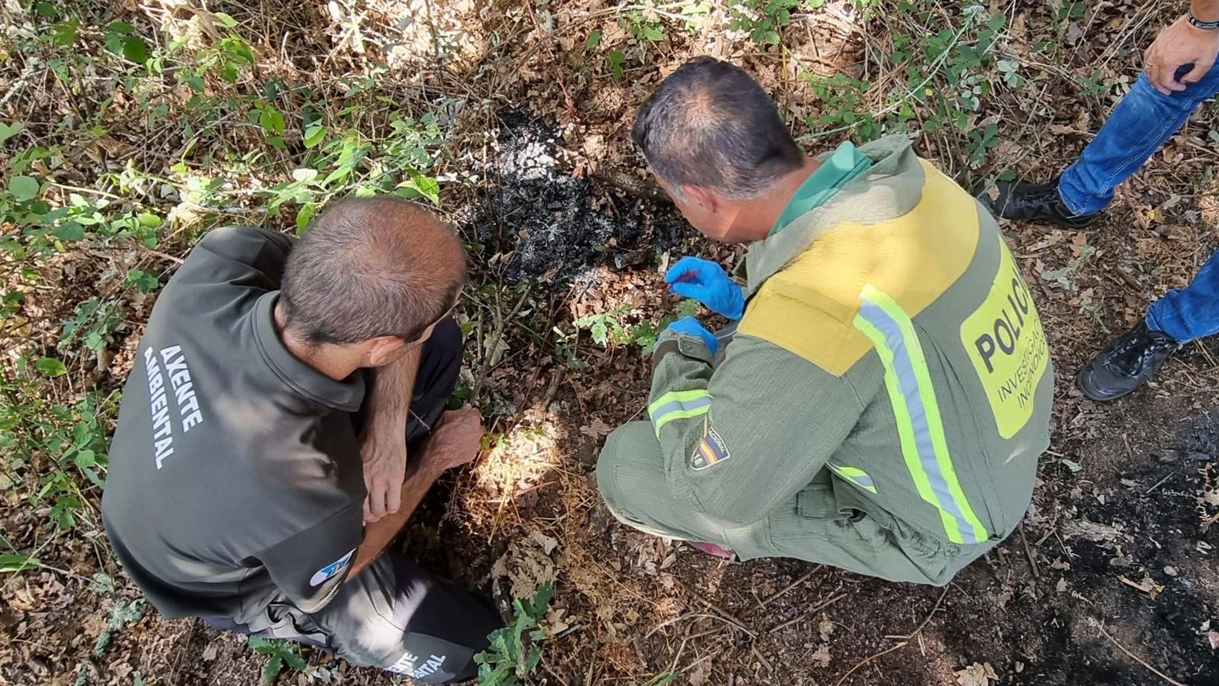 Dos agentes investigan los restos de un incendio.