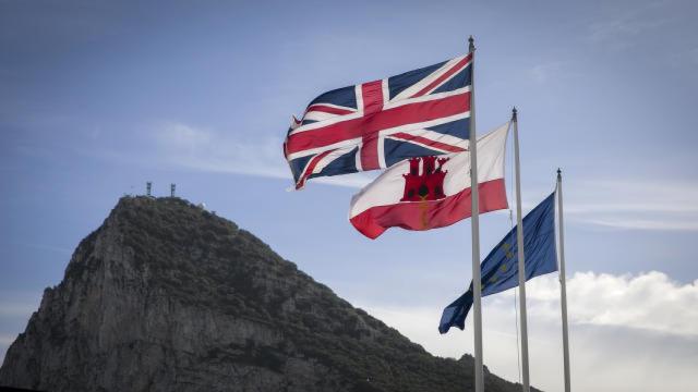 La bandera del Reino Unido, la de Gibraltar y la de la Unión Europea, ondeando en la frontera del Peñón con el territorio español.