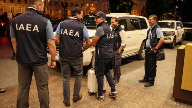 Los miembros de la misión del Organismo Internacional de Energía Atómica (OIEA) se encuentran junto a los vehículos de la ONU en el hotel cuando parten para visitar la planta de energía nuclear de Zaporizhzhia .