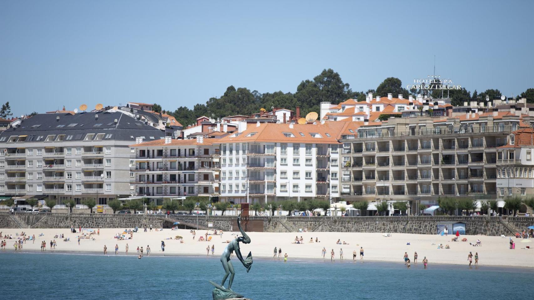 Varias personas disfrutan de la playa de Sanxenxo.
