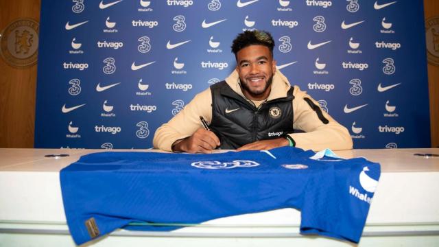 Reece James firmando una camiseta.