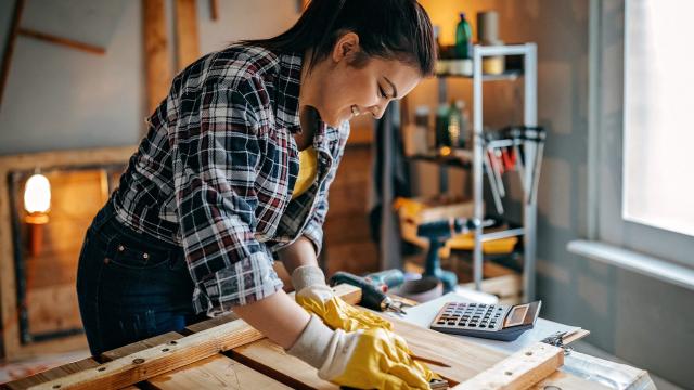 Una mujer midiendo material en un taller.