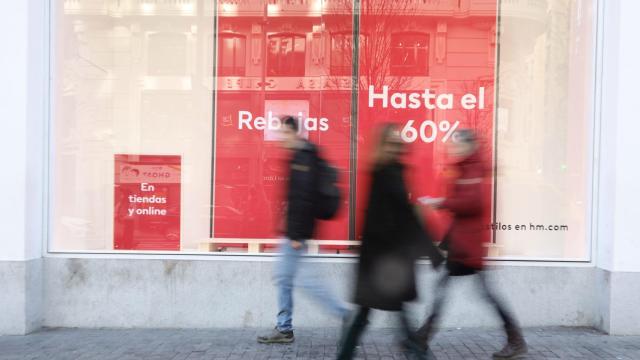 Un grupo de personas camina frente a un escaparate.