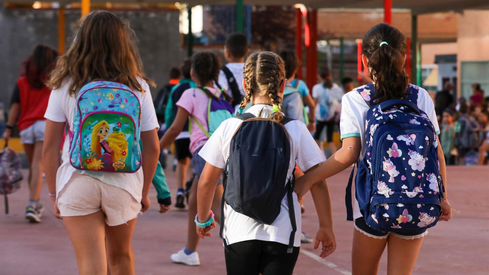 Tres niñas llegan al colegio.