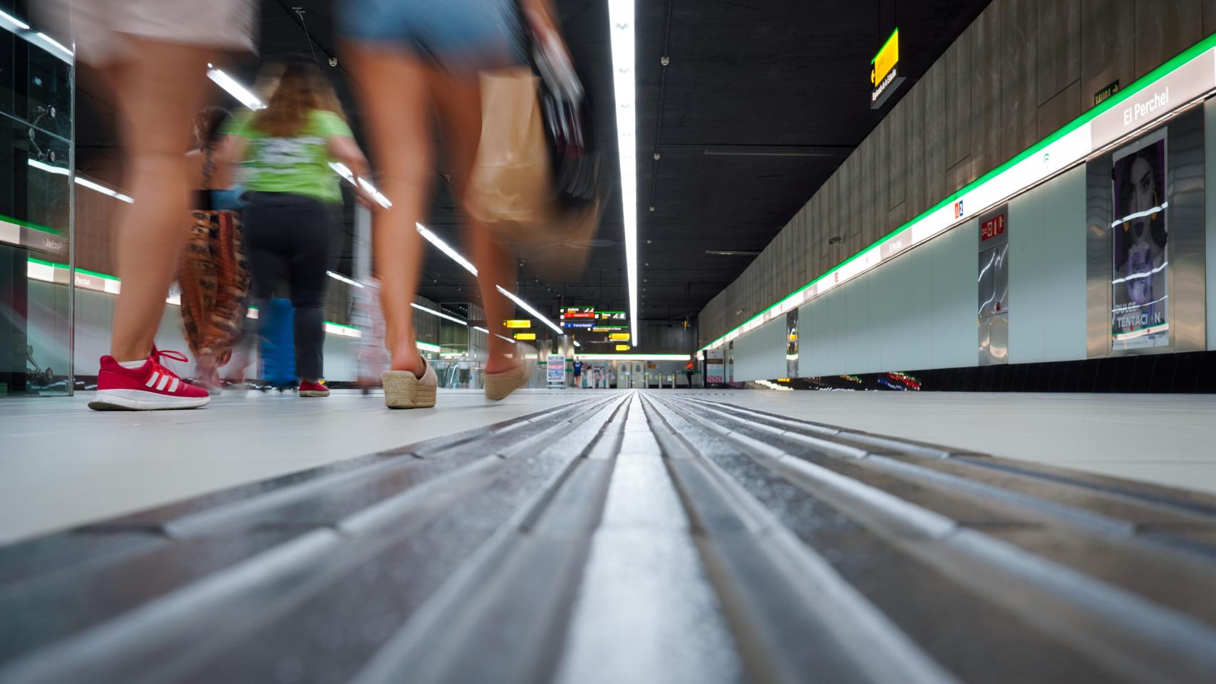 Varios pasajeros pasean por el interior de una de las estaciones del Metro de Málaga.