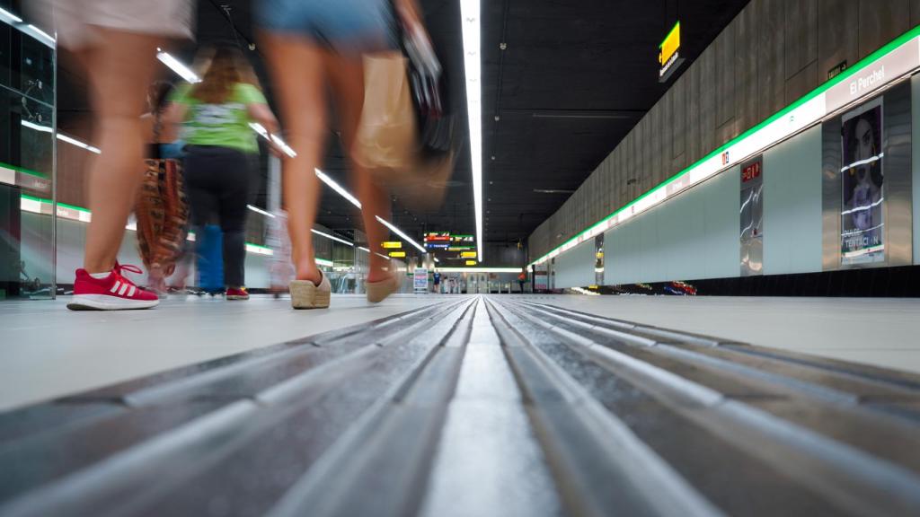 Varios pasajeros pasean por el interior de una de las estaciones del Metro de Málaga.
