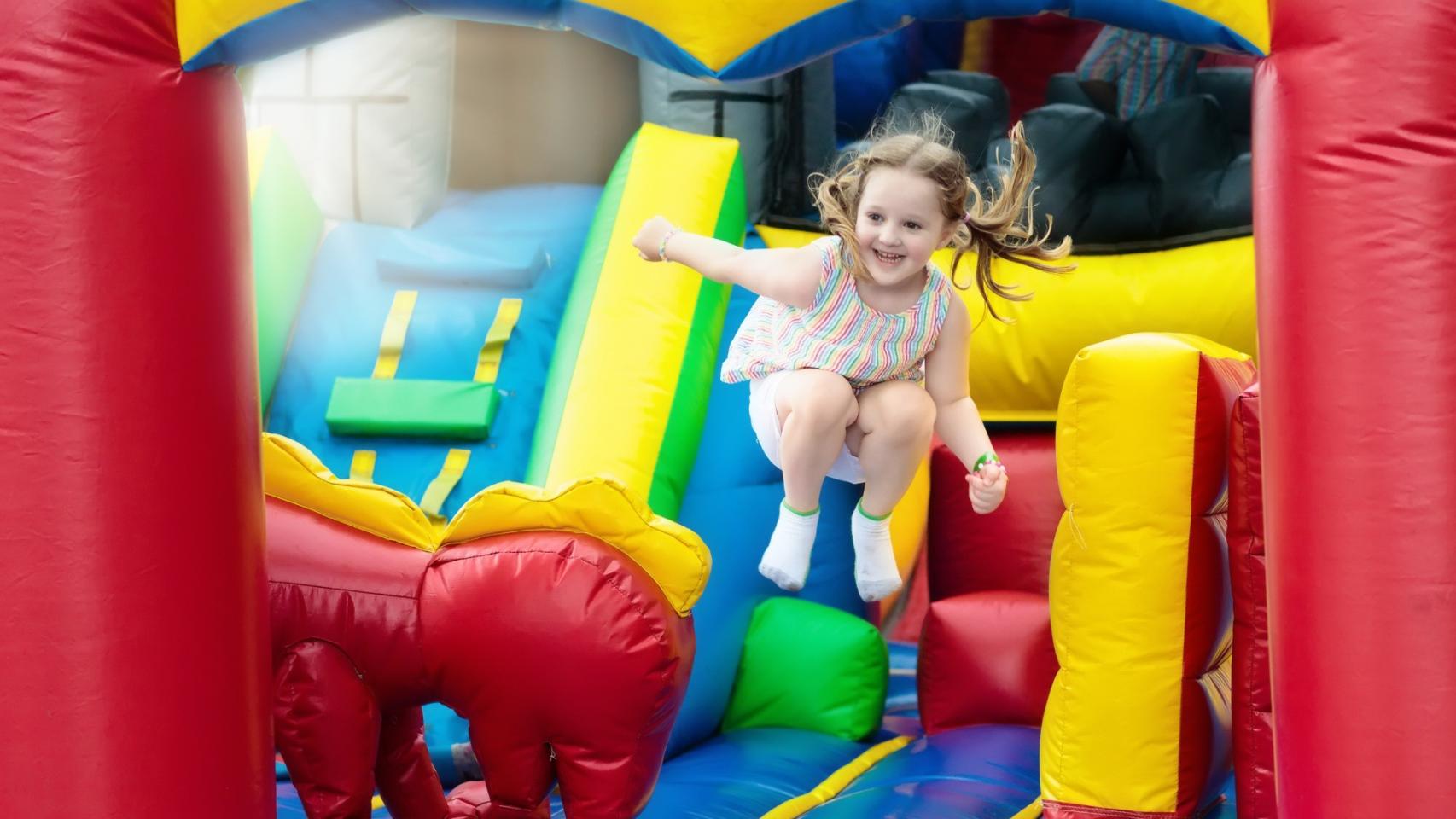 Una niña se divierte saltando en una colchoneta.