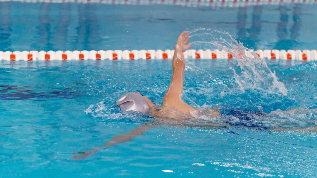 Niño practicando natación en una piscina climatizada.