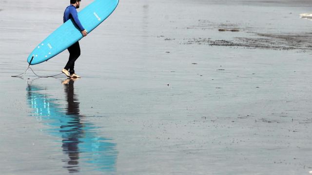 Una persona practicando surf en una playa valenciana, el pasado verano.