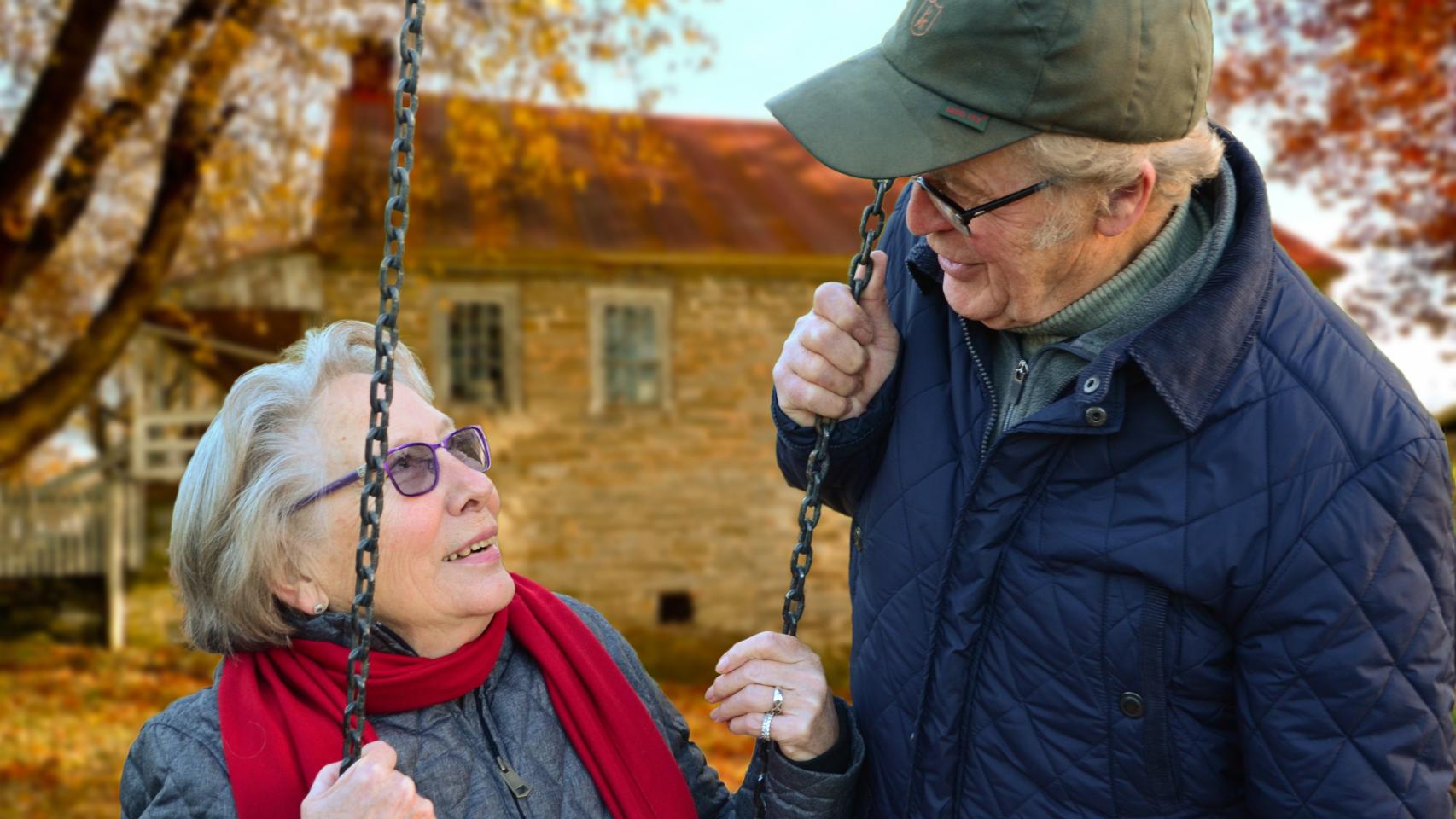 Dos jubilados charlan en el jardín de su casa.