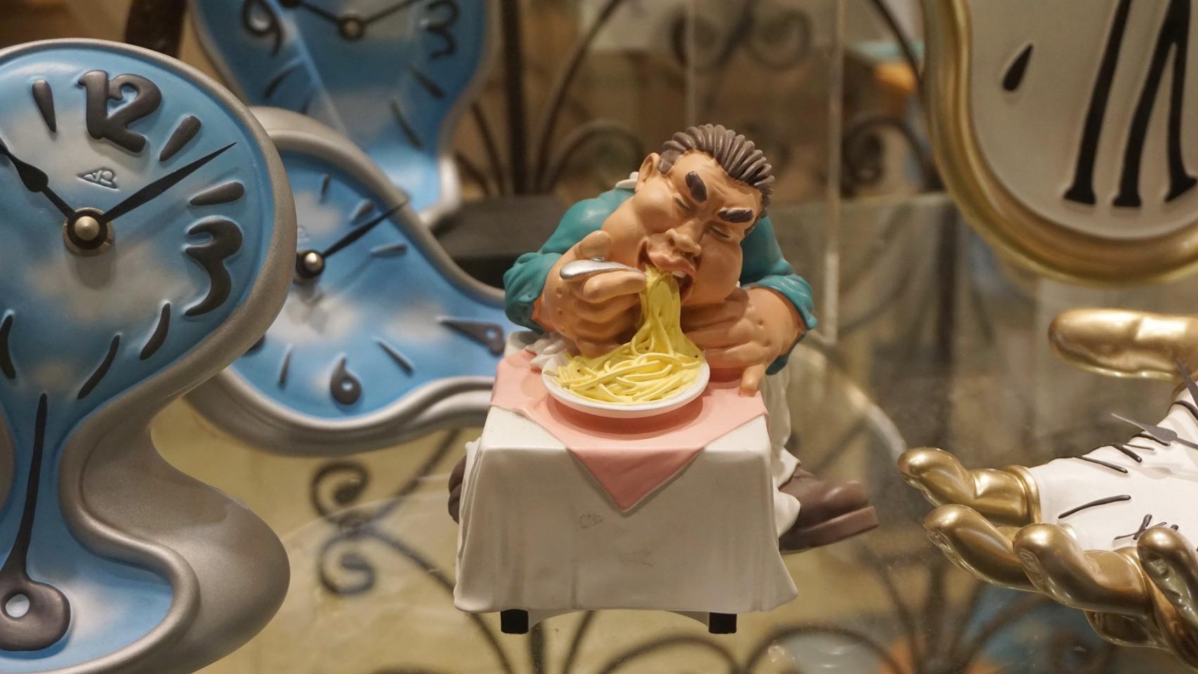 Figura de un comensal rodeado de relojes.