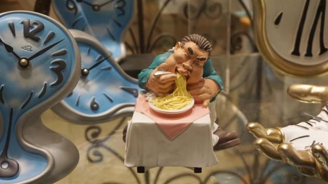 Figura de un comensal rodeado de relojes.