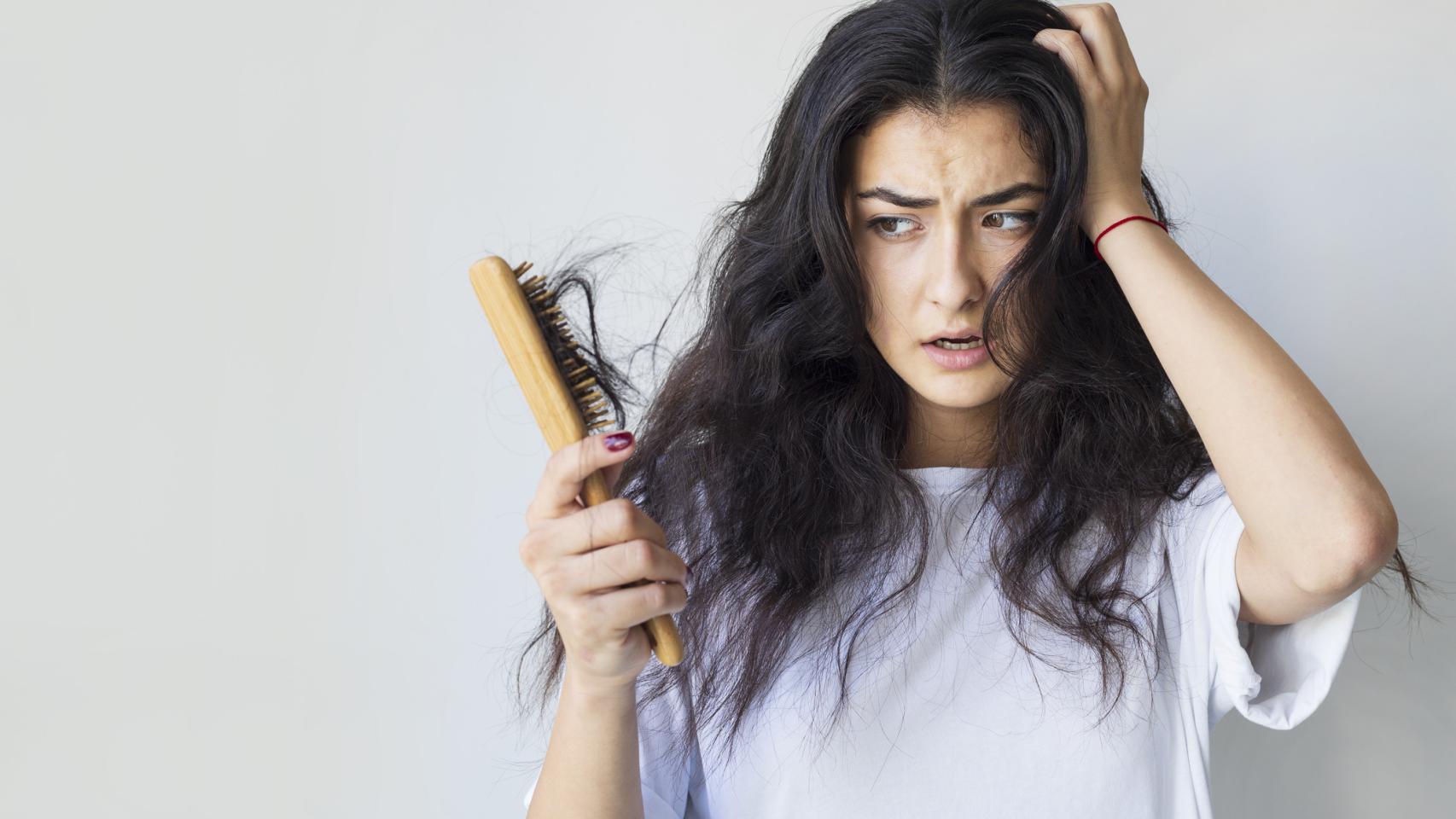 Imagen de archivo mujer con caída de pelo al cepillarse